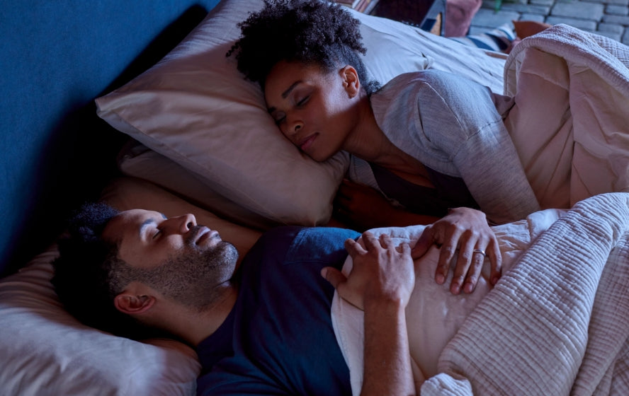 Couple sleeping on mattress